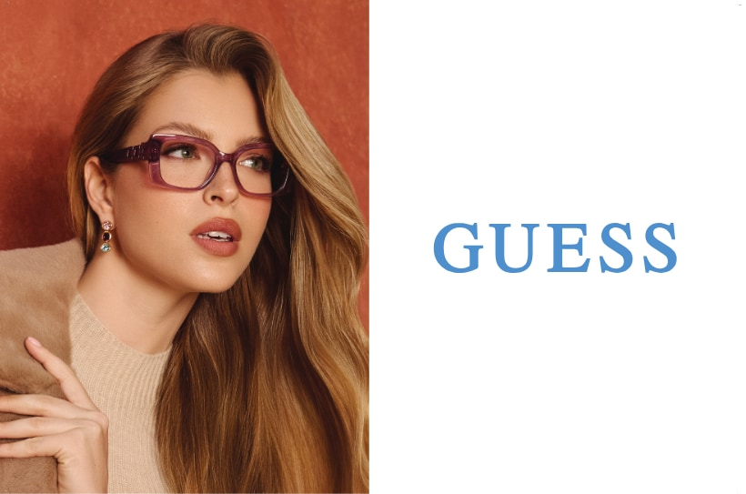Vrouw met lange blonde haren en paarse Guess-bril, elegante look tegen een warme achtergrond.