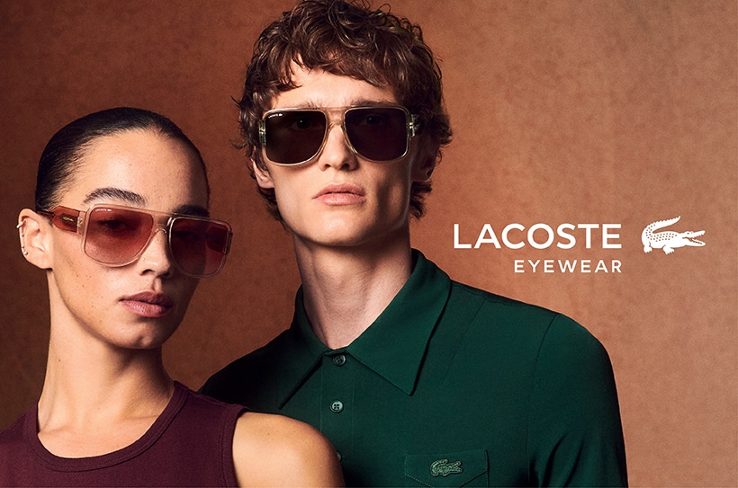 Une femme élégante aux longs cheveux noirs et un homme aux cheveux courts et bouclés, tous deux portant des lunettes de soleil tendance, debout côte à côte sur un fond aux tons chauds.