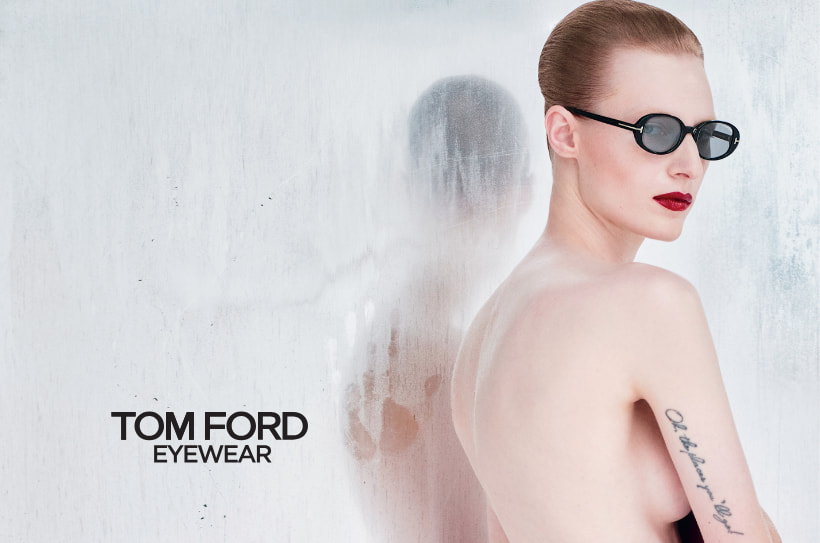 Vrouw met rode lippenstift en zwarte Tom Ford-zonnebril, minimalistische look tegen een matte achtergrond.