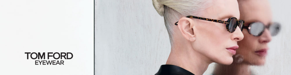 Vrouw met rode lippenstift en zwarte Tom Ford-zonnebril, minimalistische look tegen een matte achtergrond.