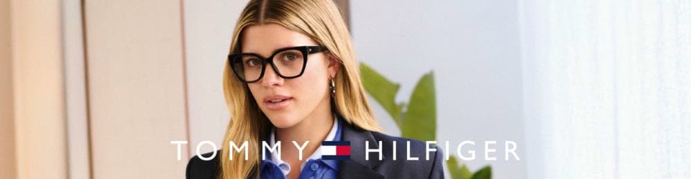 Vrouw met blond haar draagt een zwarte bril. Logo Tommy Hilfiger zichtbaar.