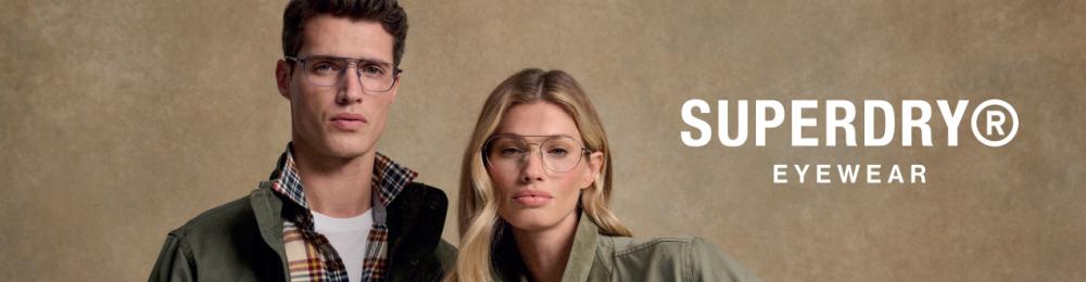 Homme et femme portant des lunettes de vue Superdry et des vestes vertes ; tous deux regardent directement l’objectif devant un fond beige ; en bas, le logo Superdry Eyewear.