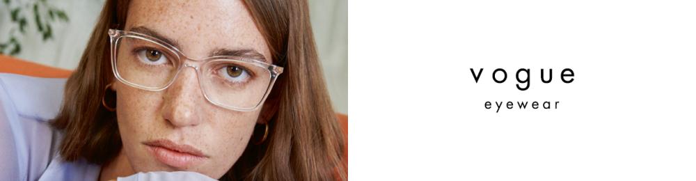 Femme portant des lunettes Vogue transparentes et un haut lilas clair, regardant droit vers la caméra.