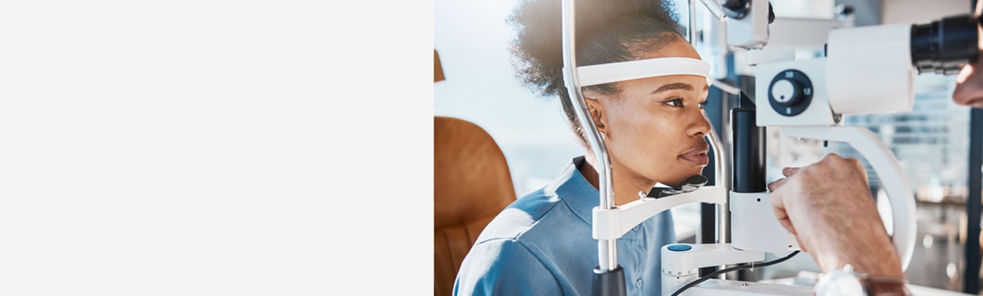 Vrouw ondergaat een oogonderzoek bij een opticien met een oogmeetapparaat.