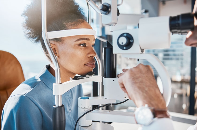 Vrouw ondergaat een oogonderzoek bij een opticien met een oogmeetapparaat.