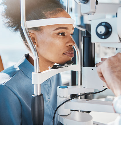 Vrouw ondergaat een oogonderzoek bij een opticien met een oogmeetapparaat.